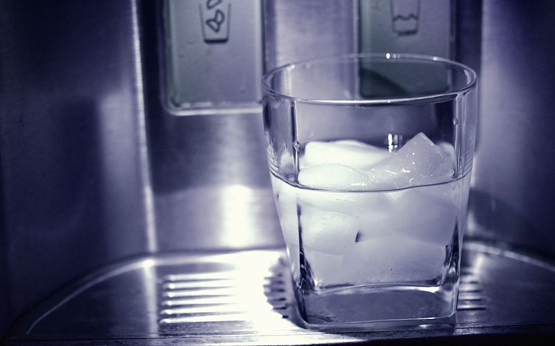 Glass of ice in a refrigerator door dispenser